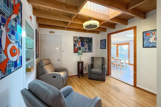 living area with hardwood / wood-style flooring, a skylight, wood ceiling, and beamed ceiling