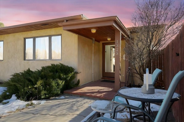 exterior entry at dusk with a patio