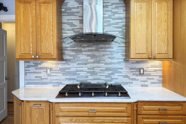 kitchen with tasteful backsplash, stainless steel gas stovetop, and wall chimney range hood