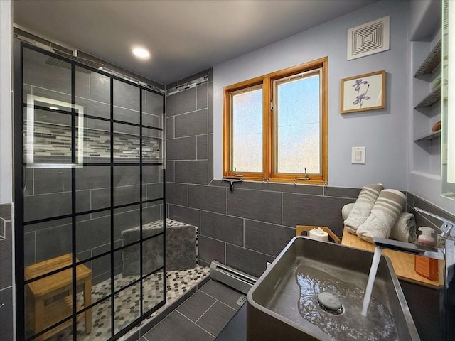 bathroom featuring tile walls, tile patterned flooring, tiled shower, and baseboard heating