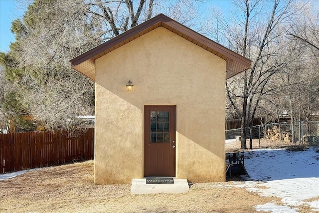 snow covered back of property with a shed