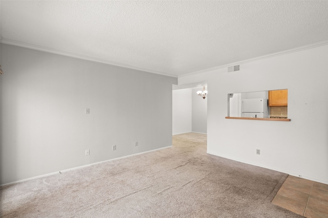 empty room with an inviting chandelier, crown molding, light carpet, and a textured ceiling