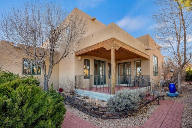 pueblo-style house featuring a porch