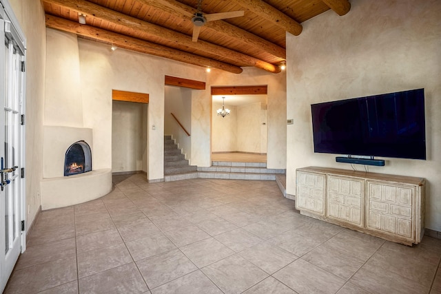 unfurnished living room featuring beamed ceiling, tile patterned floors, an inviting chandelier, and wooden ceiling