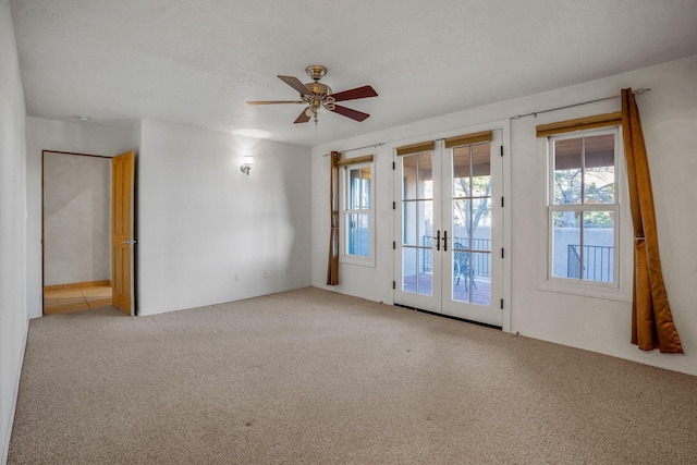 carpeted empty room featuring a textured ceiling, french doors, and ceiling fan