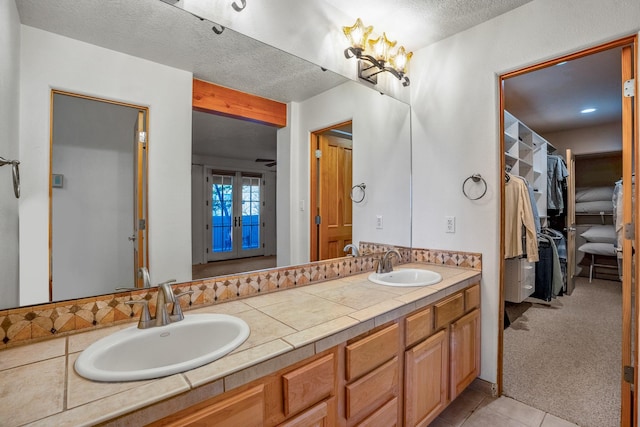 bathroom with vanity, tile patterned flooring, and a textured ceiling