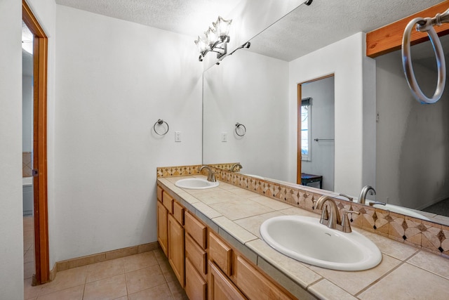 bathroom featuring vanity, tile patterned floors, and a textured ceiling