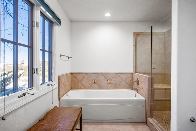 bathroom featuring shower with separate bathtub, tile patterned floors, and a textured ceiling