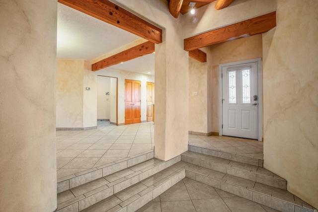 foyer entrance featuring light tile patterned floors and beam ceiling