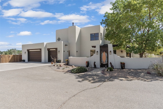 pueblo revival-style home with a garage