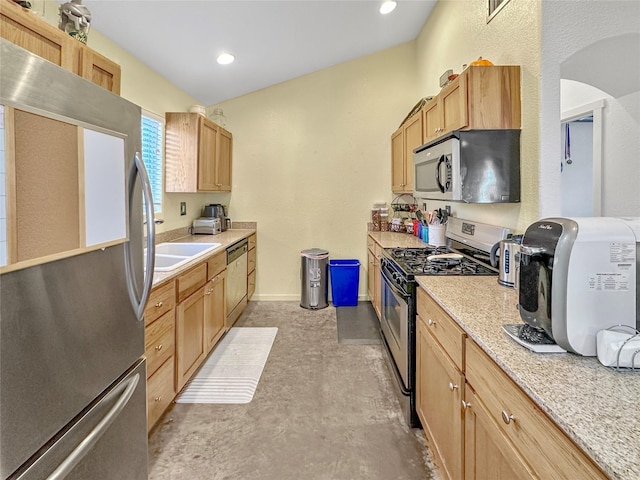 kitchen with appliances with stainless steel finishes, sink, and light stone counters