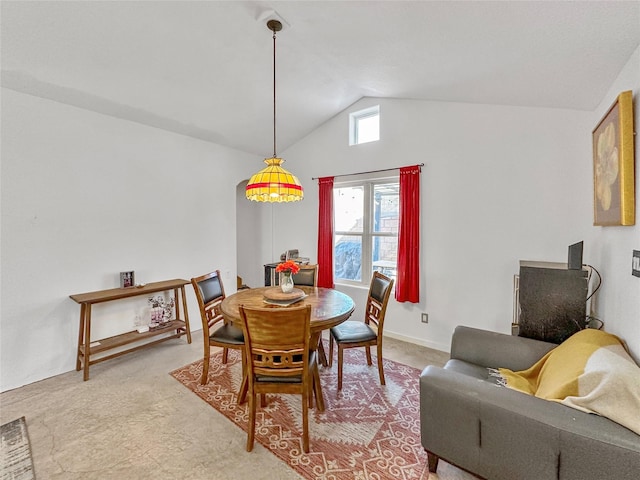 carpeted dining room featuring vaulted ceiling