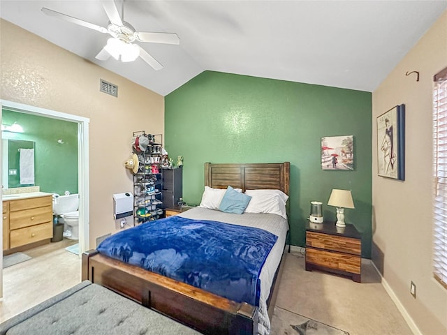 carpeted bedroom with vaulted ceiling, ceiling fan, and ensuite bathroom