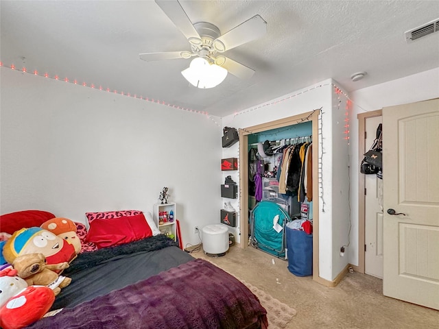 bedroom with a textured ceiling, ceiling fan, and a closet