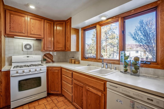 kitchen featuring sink, white appliances, and decorative backsplash