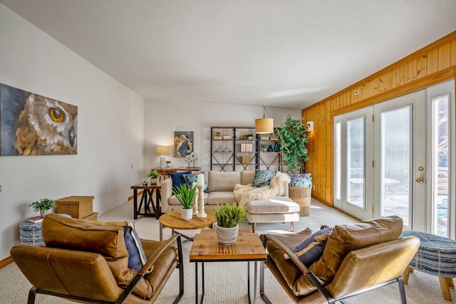 carpeted living room with wood walls