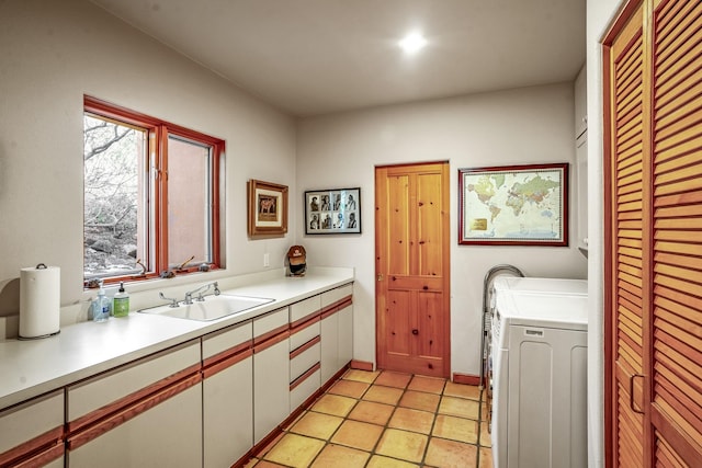 laundry room featuring cabinets, a healthy amount of sunlight, and sink