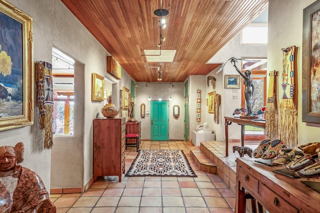 hallway featuring light tile patterned floors and wood ceiling