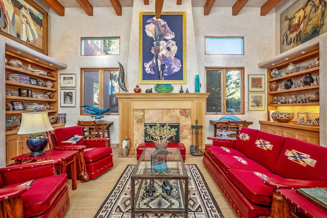 sitting room featuring a tiled fireplace, a towering ceiling, light carpet, and beam ceiling