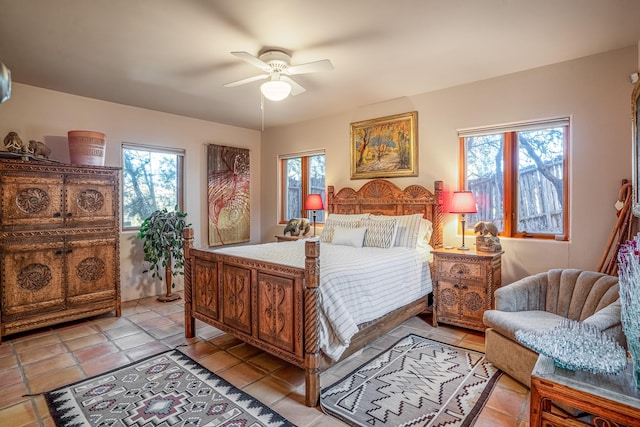 bedroom featuring ceiling fan, multiple windows, and light tile patterned floors