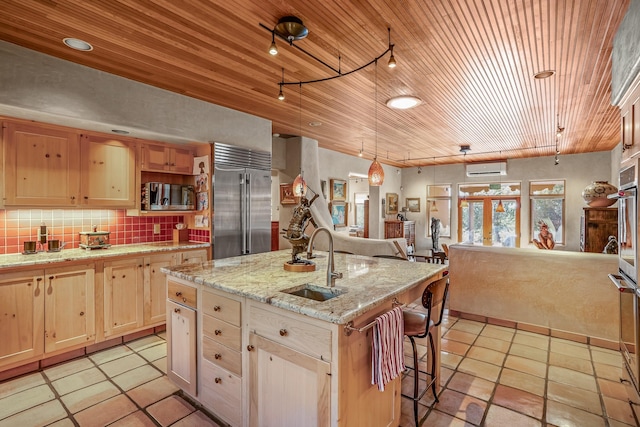 kitchen with sink, tasteful backsplash, wood ceiling, a center island with sink, and appliances with stainless steel finishes