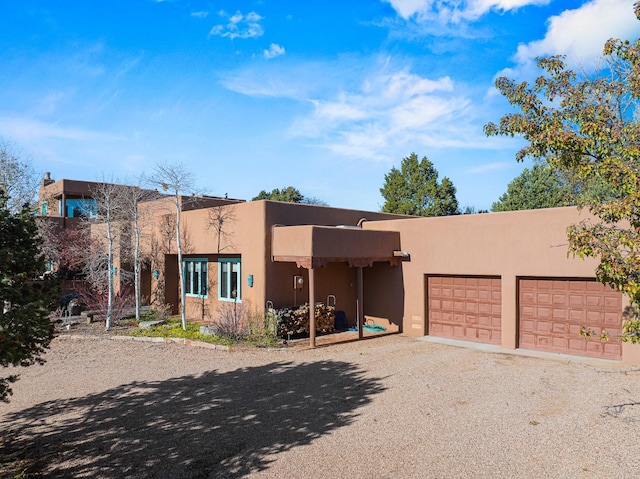 pueblo-style home featuring a garage