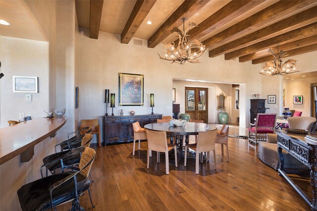 dining area featuring hardwood / wood-style flooring, beamed ceiling, and a high ceiling