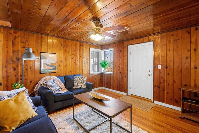 living room featuring wooden ceiling, wood walls, ceiling fan, and light hardwood / wood-style flooring