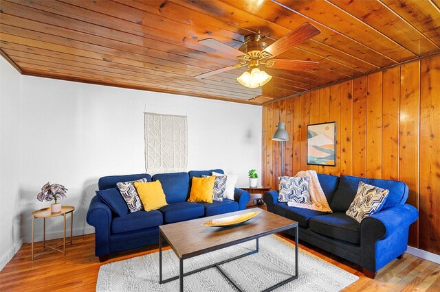 living room with ceiling fan, light hardwood / wood-style flooring, crown molding, and wooden ceiling