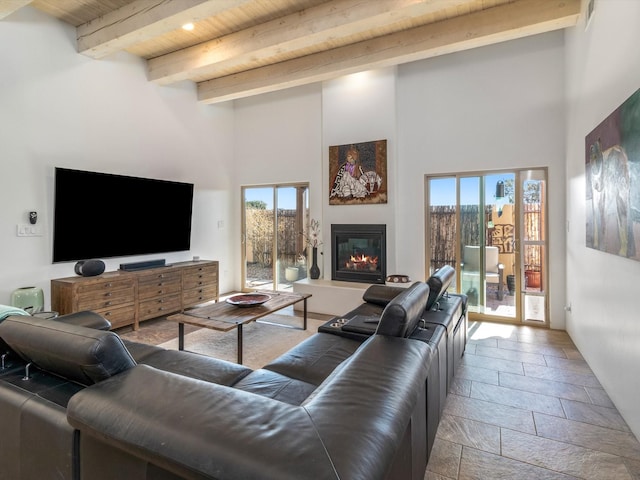 living room featuring beamed ceiling, a towering ceiling, and wood ceiling