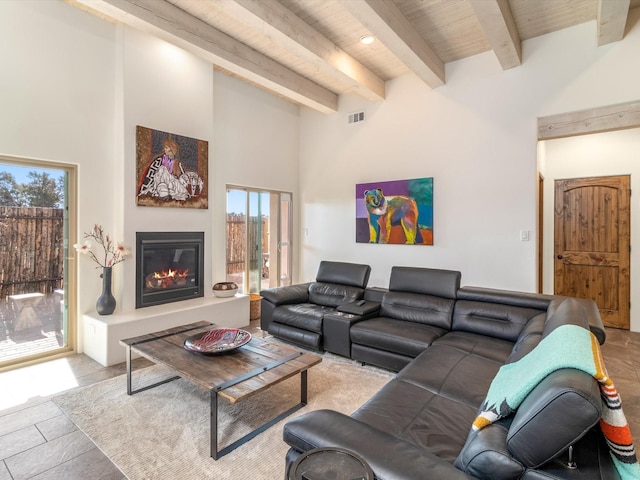 living room featuring a high ceiling, light tile patterned floors, and beam ceiling