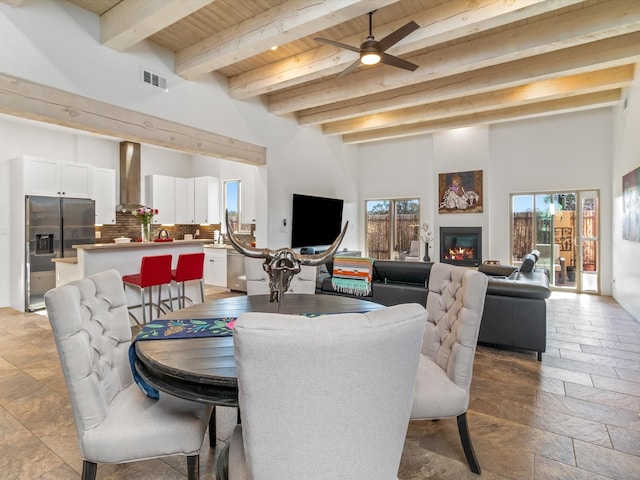 dining space featuring beamed ceiling, ceiling fan, and wooden ceiling