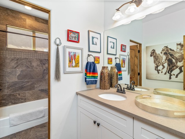 bathroom with tiled shower / bath and vanity