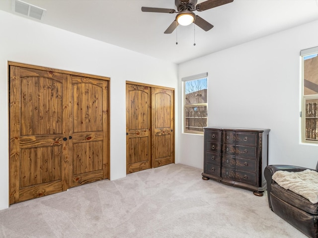 living area with ceiling fan and light colored carpet