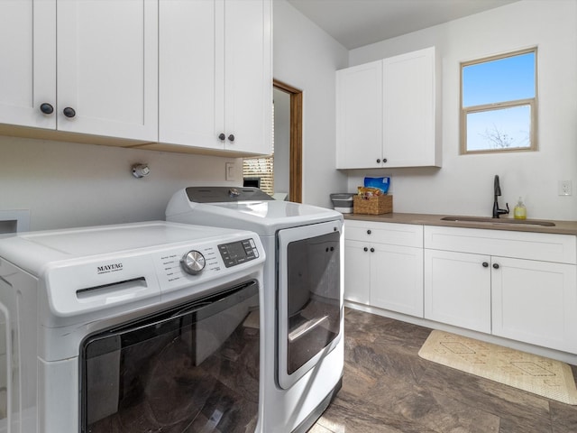 washroom with cabinets, washer and clothes dryer, and sink