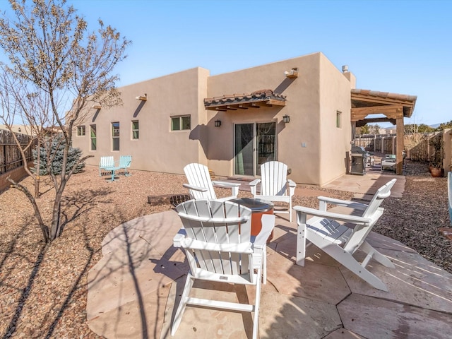 back of property featuring a patio area and an outdoor fire pit