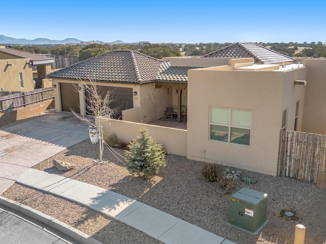 pueblo revival-style home featuring a garage and a mountain view