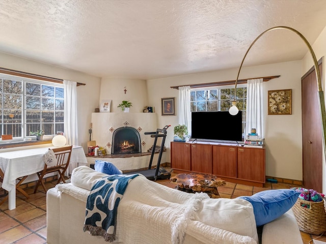 tiled living room featuring a textured ceiling and a fireplace