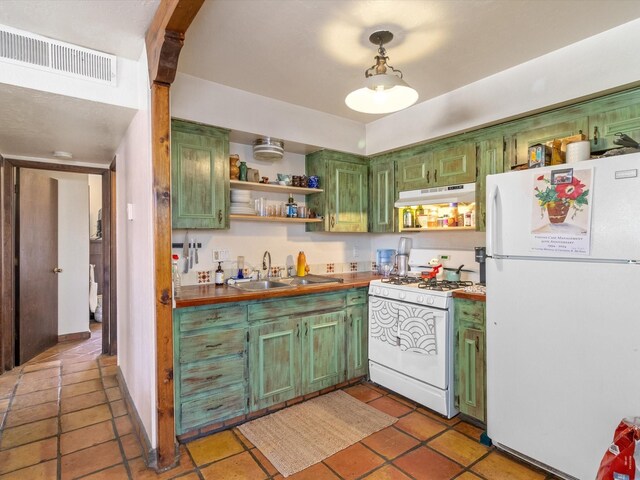 kitchen featuring butcher block counters, sink, light tile patterned flooring, and white appliances