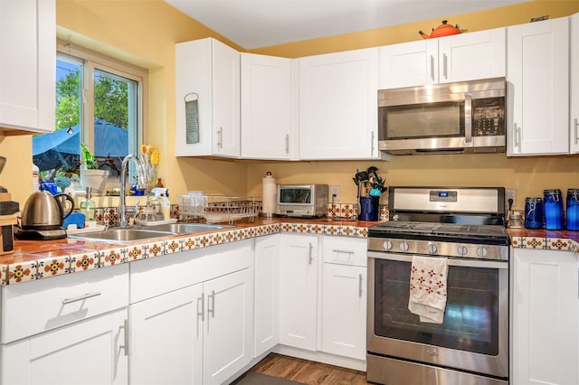 kitchen featuring white cabinetry, stainless steel appliances, light hardwood / wood-style floors, and sink