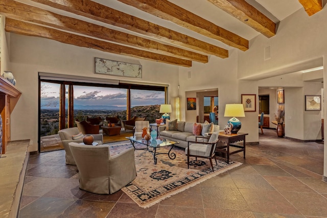 living room featuring beam ceiling and a high ceiling