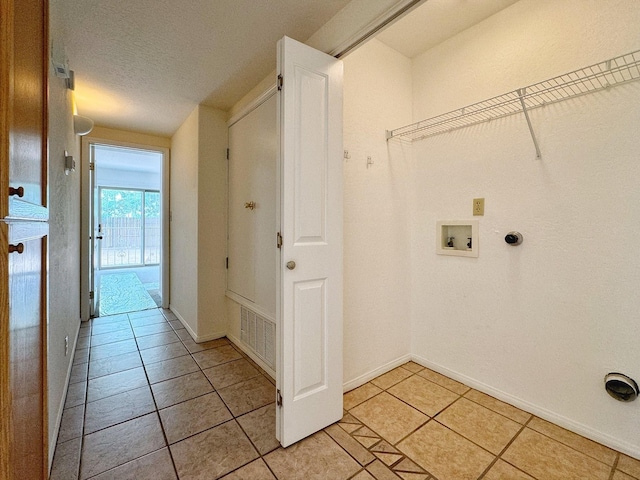 laundry room with hookup for a washing machine, light tile patterned flooring, and a textured ceiling