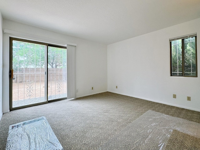 carpeted spare room with a textured ceiling