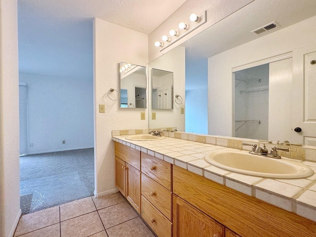 bathroom with vanity, tile patterned flooring, and a textured ceiling