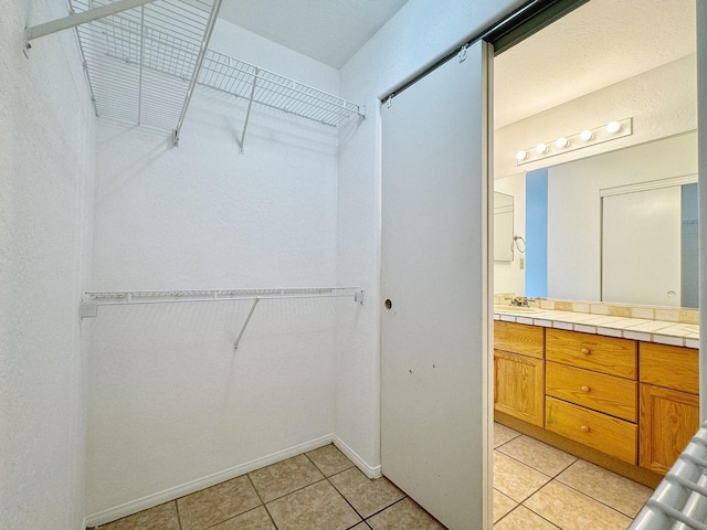 walk in closet featuring light tile patterned floors and sink