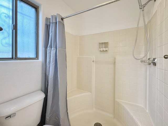 bathroom with toilet and curtained shower