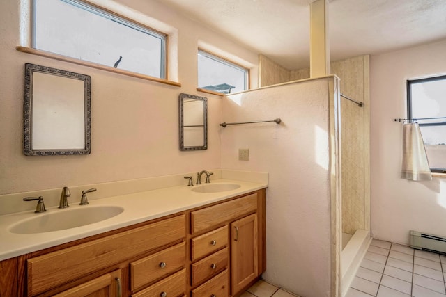 bathroom featuring tile patterned flooring, vanity, tiled shower, and a baseboard radiator