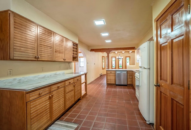 kitchen featuring dark tile patterned floors, white appliances, and kitchen peninsula