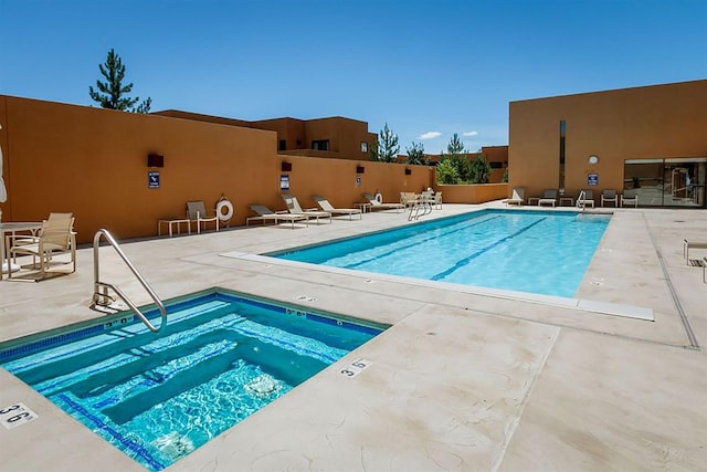 view of pool with a community hot tub and a patio