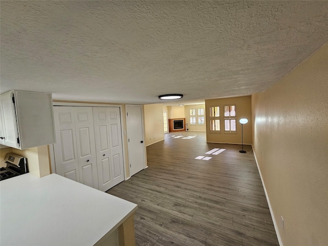 corridor featuring hardwood / wood-style flooring and a textured ceiling